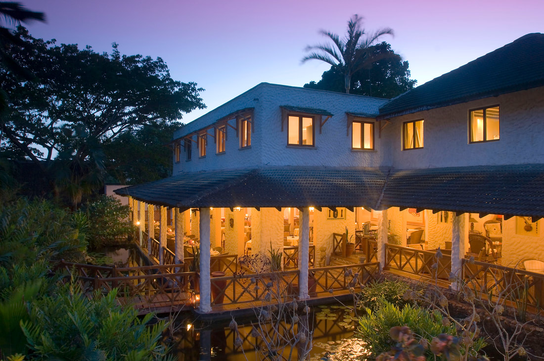 Looking at an open air restaurant at dusk at the Pinewood Beach Resort & Spa