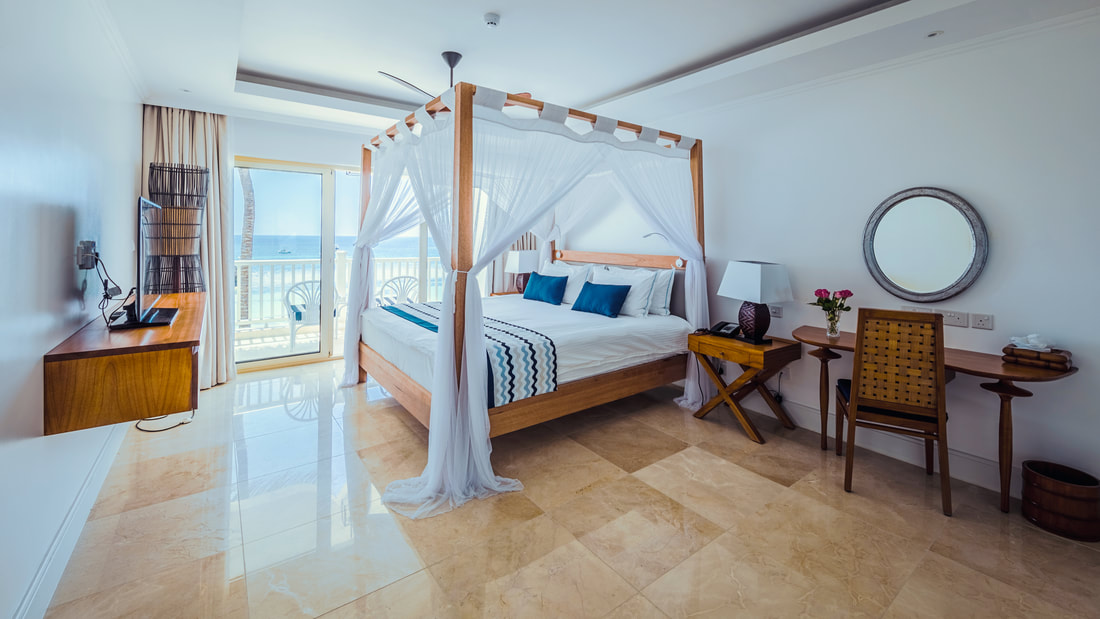 a double bedroom with a balcony that looks out to sea