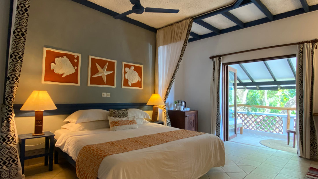 A double bedroom with a balcony at the Pinewood Beach Resort & Spa