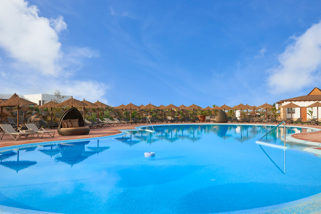 the pool area at the Melia Llana Beach Resort with sunloungers and umbrellas