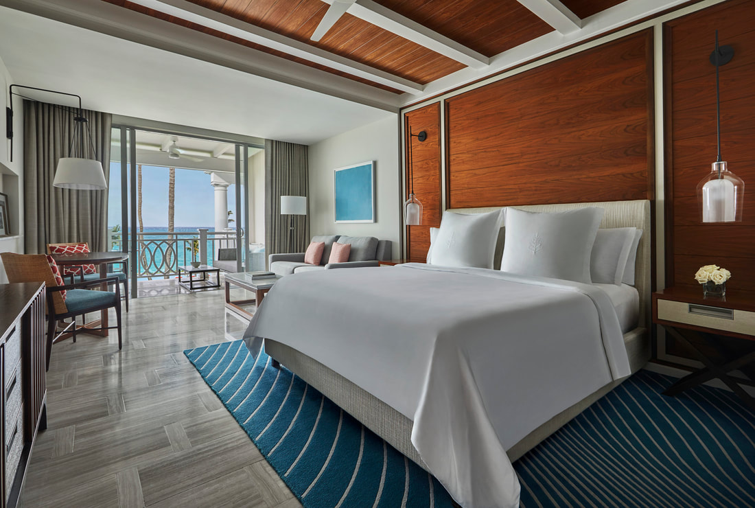 a double bedroom with a balcony that overlooks the sea