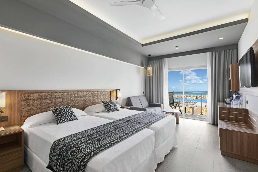 a Twin bedroom with a balcony that looks out to the resort